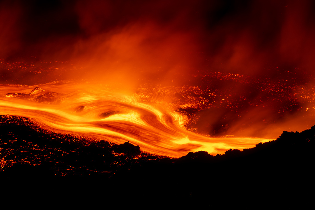 Eruptive activity continues on Mount Etna, where lava flows continue to descend on the slopes of the volcano, as seen from Serracozzo near Catania, Italy, early Tuesday, Aug. 11, 2026. (AP Photo/Simone Genovese)