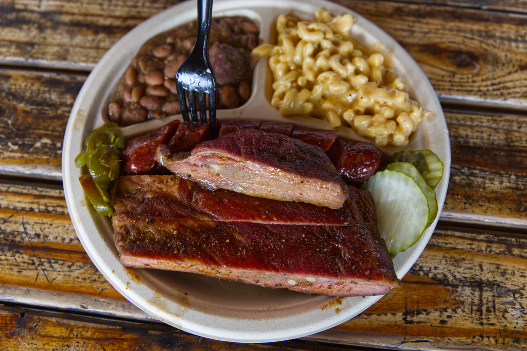 A plate of ribs and sausage with two sides is served at the Little Miss BBQ in Phoenix, Tuesday May 19, 2026. (AP Photo/Dario Lopez-Mills)