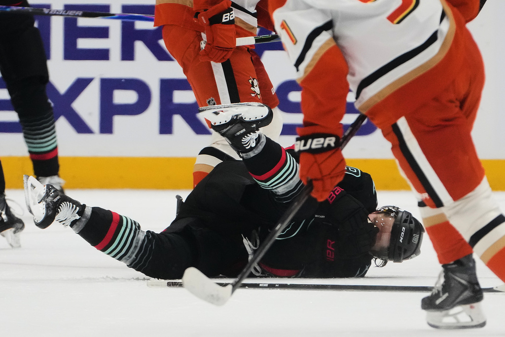 Seattle Kraken left wing Jared McCann falls after getting hit by the puck against the Anaheim Ducks during the first period of an NHL hockey game Friday, Jan. 23, 2026, in Seattle. (AP Photo/Lindsey Wasson)