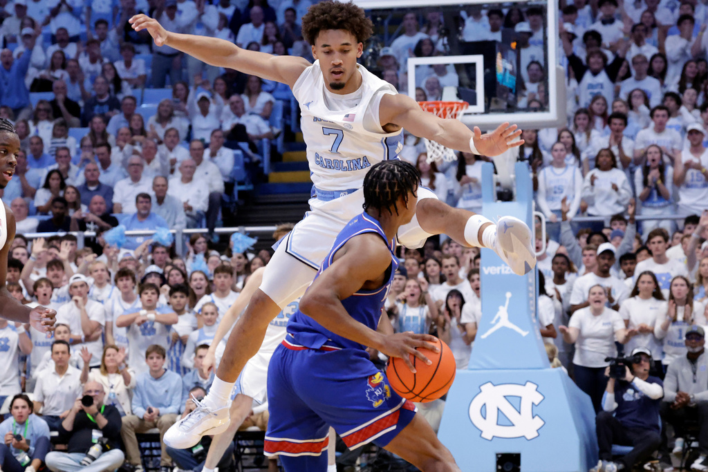 North Carolina guard Seth Trimble (7) defends against Kansas guard Elmarko Jackson, bottom, during the first half of an NCAA college basketball game Friday, Nov. 7, 2025, in Chapel Hill, N.C. (AP Photo/Chris Seward)