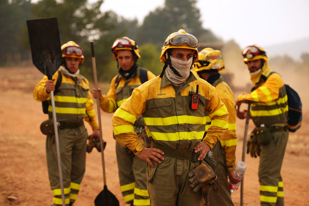 Forest rangers take a break before returning to work on the fire near Condemios de Arriba, Guadalajara province, Spain, Wednesday, July 22, 2026, after a wildfire scorched tens of thousands of hectares in one of Spain's largest wildfires in recent years. (AP Photo/Manu Fernandez)