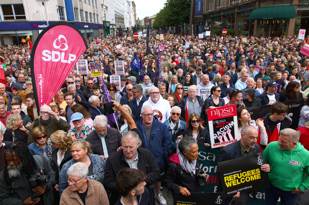 People gather during an anti-racism rally outside Belfast City Hall sparked by a knife attack on a man in north Belfast on Monday, in Belfast, Saturday June 13, 2026. (Peter Morrison/PA via AP)