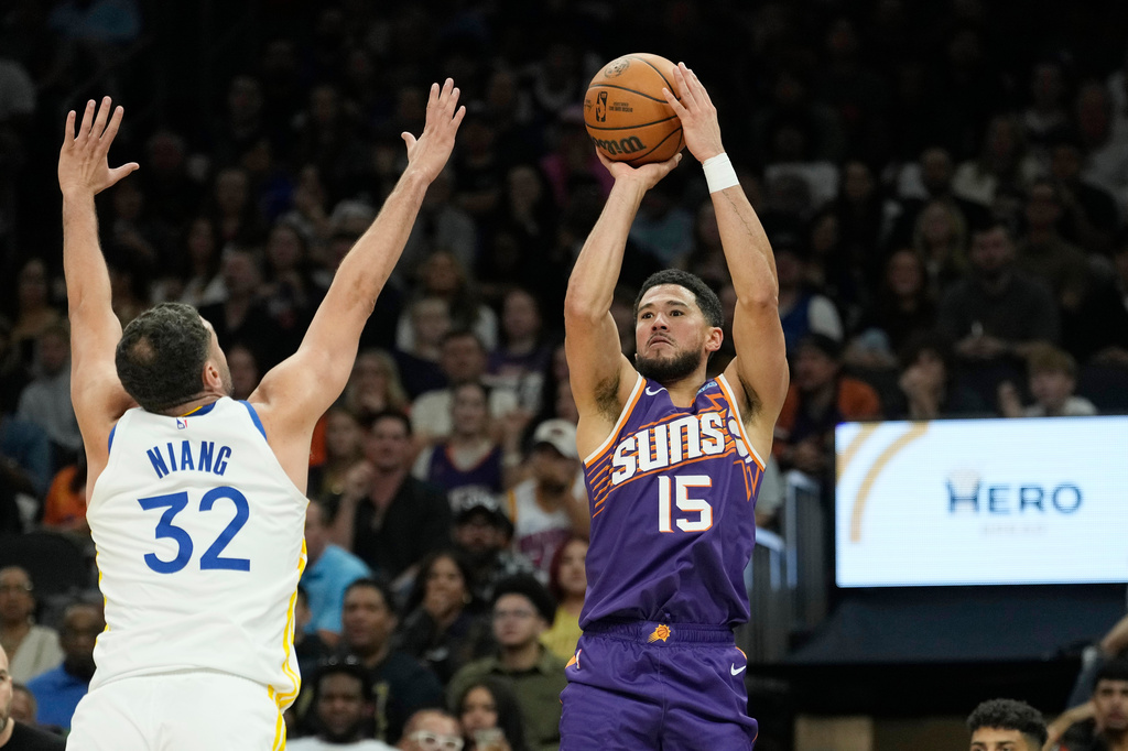 Phoenix Suns guard Devin Booker (15) shoots a 3-pointer over Golden State Warriors forward Georges Niang (32) during an NBA basketball game, Saturday, Oct. 24, 2026, in Phoenix. (AP Photo/Ross D. Franklin)