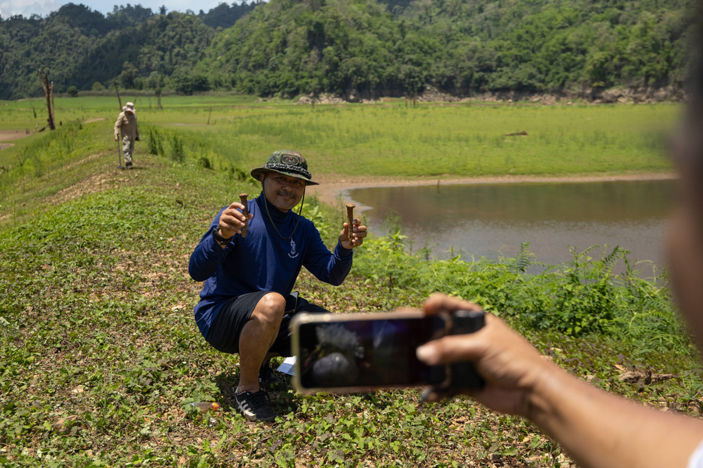 Local residents take pictures of artefacts from Nithe Station, part of the infamous World War II "Death Railway," in Sangkhlaburi, Thailand on Friday, May 29, 2026. (AP Photo/Anton L. Delgado)