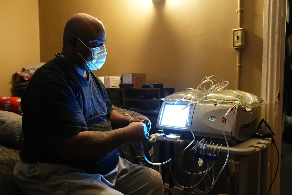 Ahmad Collins, a city government worker and former Penn State linebacker, prepares for his nightly dialysis treatment at his home in Harrisburg, Pa., Thursday, Dec. 11, 2025. (AP Photo/Matt Rourke)