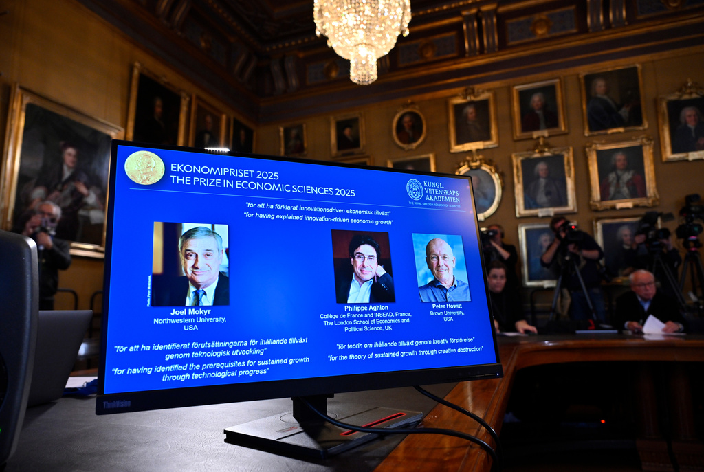 Joel Mokyr, from left, Philippe Aghion and Peter Howitt (on screen) announced as the recipients of the Nobel Memorial Prize in Economics during a press conference at the Royal Swedish Academy of Sciences in Stockholm, Sweden, Monday, Oct. 13, 2025. (Anders Wiklund/TT News Agency via AP)