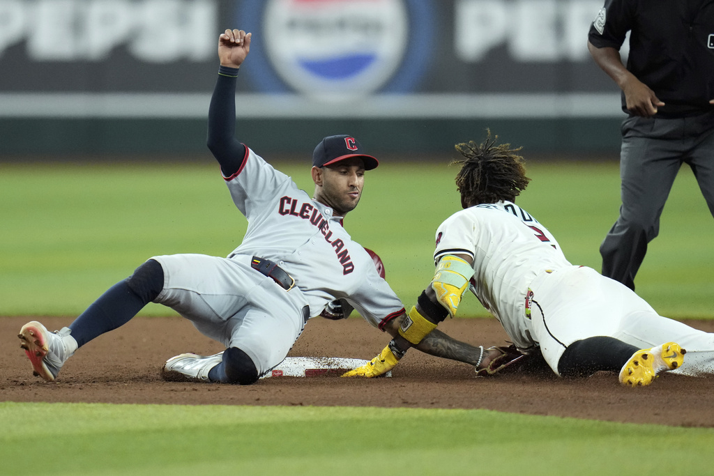 Arizona Diamondbacks' Geraldo Perdomo, right, steals second base as Cleveland Guardians second baseman Brayan Rocchio, left, is unable to make a catch during the seventh inning of a baseball game Tuesday, Aug. 19, 2025, in Phoenix. (AP Photo/Ross D. Franklin)