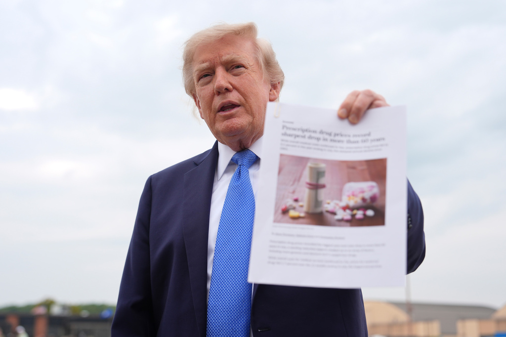 President Donald Trump holds an article about prescription drug prices as he speaks with reporters before boarding Air Force One, Friday, Aug. 14, 2026, at Joint Base Andrews, Md. (AP Photo/Julia Demaree Nikhinson)