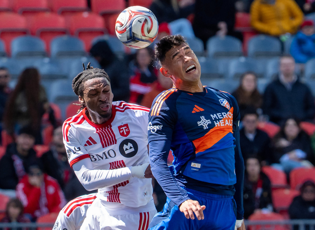 FC Cincinnati defender Gilberto Flores, right, heads the ball over Toronto FC defender Zane Monlouis uring the first half of an MLS soccer game in Toronto, Saturday, April 11, 2026. (Frank Gunn/The Canadian Press via AP)