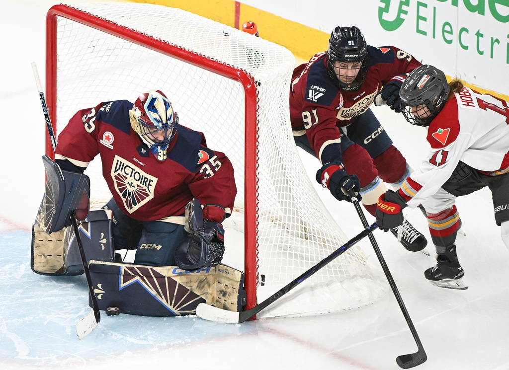 Ottawa Charge's Brooke Hobson (11) attempts a wraparound on Montreal Victoire goaltender Ann-Renee Desbiens (35) as Victoire's Maggie Flaherty (91) defends during third period PWHL hockey action in Laval, Quebec, Canada, Saturday, Jan. 24, 2026. (Graham Hughes/The Canadian Press via AP)