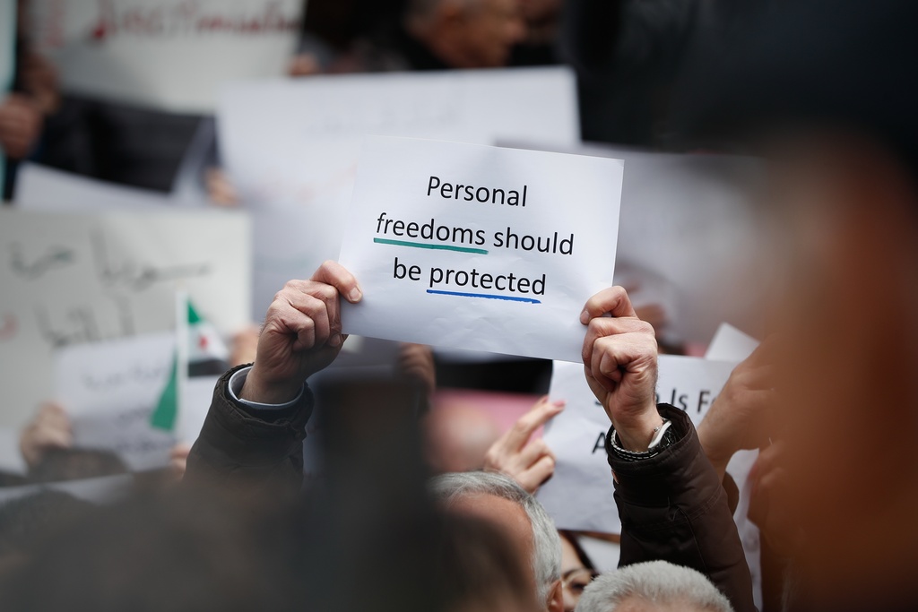 Protesters hold signs during a demonstration against new restrictions on alcohol sales in Damascus, Syria, Sunday, March 22, 2026.(AP Photo/Omar Sanadiki)