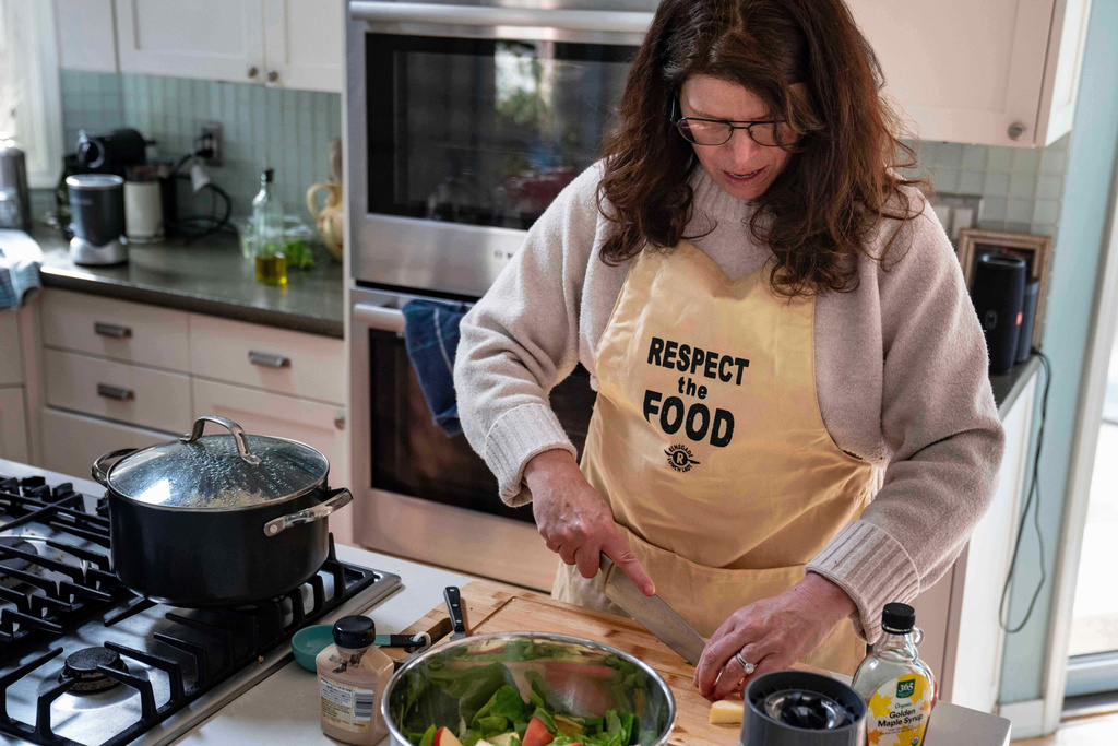 CEO of the Chef Ann Foundation, Mara Fleishman, a winner of this year's Elevate Prize, chops apples for a salad at her home, Monday, Feb. 16, 2026, in Boulder, Colo. (AP Photo/Rebecca Slezak)