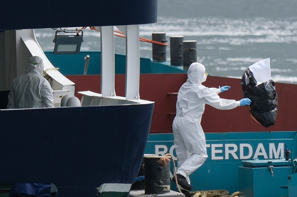 People in protective gear remove waste from the MV Hondius cruise ship after its arrival at the Port of Rotterdam, Netherlands, Monday, May 18, 2026. (AP Photo/Patrick Post)
