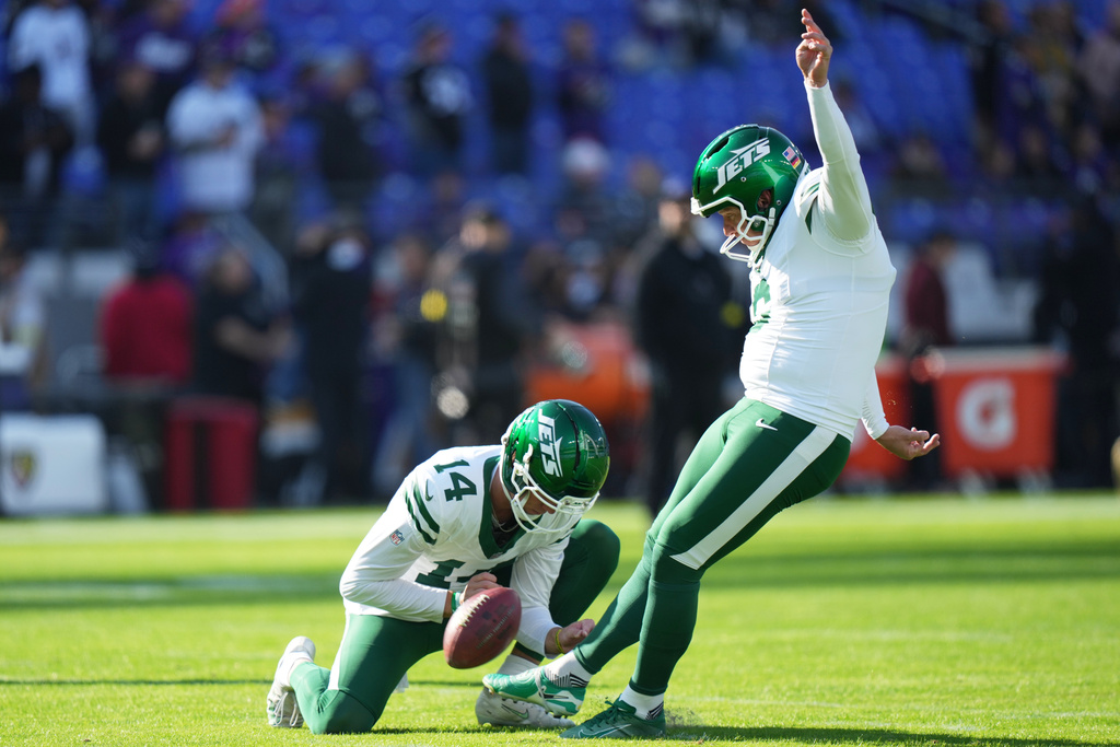 New York Jets place kicker Nick Folk, right, kicks as punter Austin McNamara holds the ball before an NFL football game against the Baltimore Ravens, Sunday, Nov. 23, 2025, in Baltimore. (AP Photo/Stephanie Scarbrough)