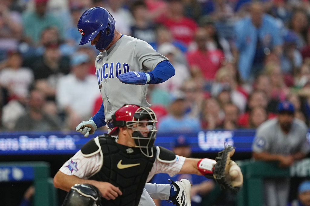 Chicago Cubs' Matt Shaw scores past Philadelphia Phillies catcher J.T. Realmuto during the third inning of a baseball game, Wednesday, April 15, 2026, in Philadelphia. (AP Photo/Matt Rourke)
