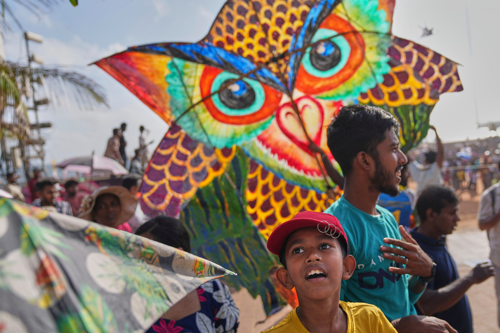 A boy watches participants fly kite during the Colombo International Kite Festival in Colombo, Sri Lanka, Sunday, Aug. 24, 2025. (AP Photo/Eranga Jayawardena)