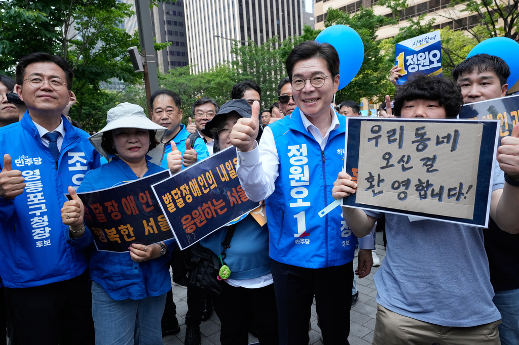 Seoul mayoral candidate Chong Won-o, third from right, of the ruling Democratic Party poses with supporters during an election campaign for June 3 nationwide simultaneous local elections in Seoul, South Korea, Tuesday, June 2, 2026. (AP Photo/Ahn Young-joon)