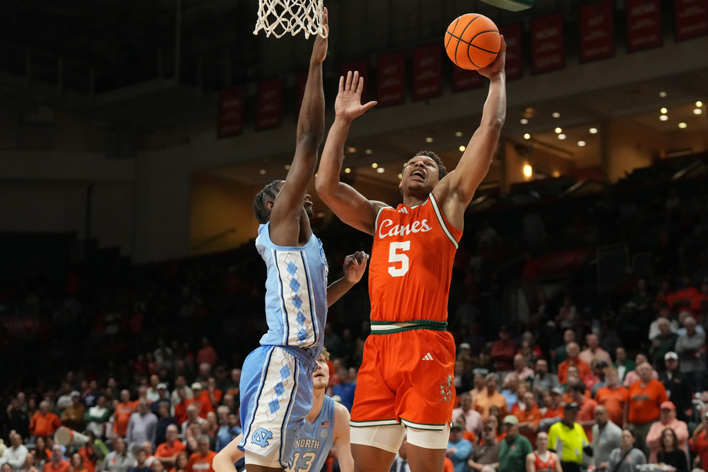 Miami forward Malik Reneau (5) drives to the basket as North Carolina forward Caleb Wilson (8) defends during the first half of an NCAA college basketball game, Tuesday, Feb. 10, 2026, in Coral Gables, Fla. (AP Photo/Marta Lavandier)