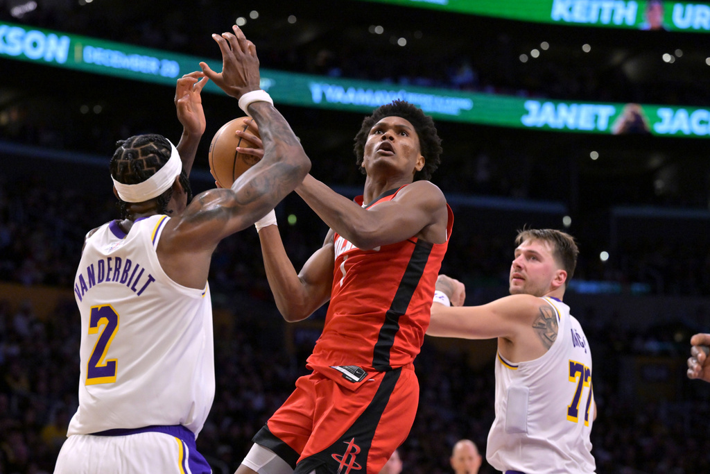 Houston Rockets guard Amen Thompson drives past Los Angeles Lakers forward Jarred Vanderbilt (2) and Lakers' guard Luka Doncic for a basket during the first half of an NBA basketball game, Thursday, Dec. 25, 2025, in Los Angeles. (AP Photo/Jayne Kamin-Oncea)