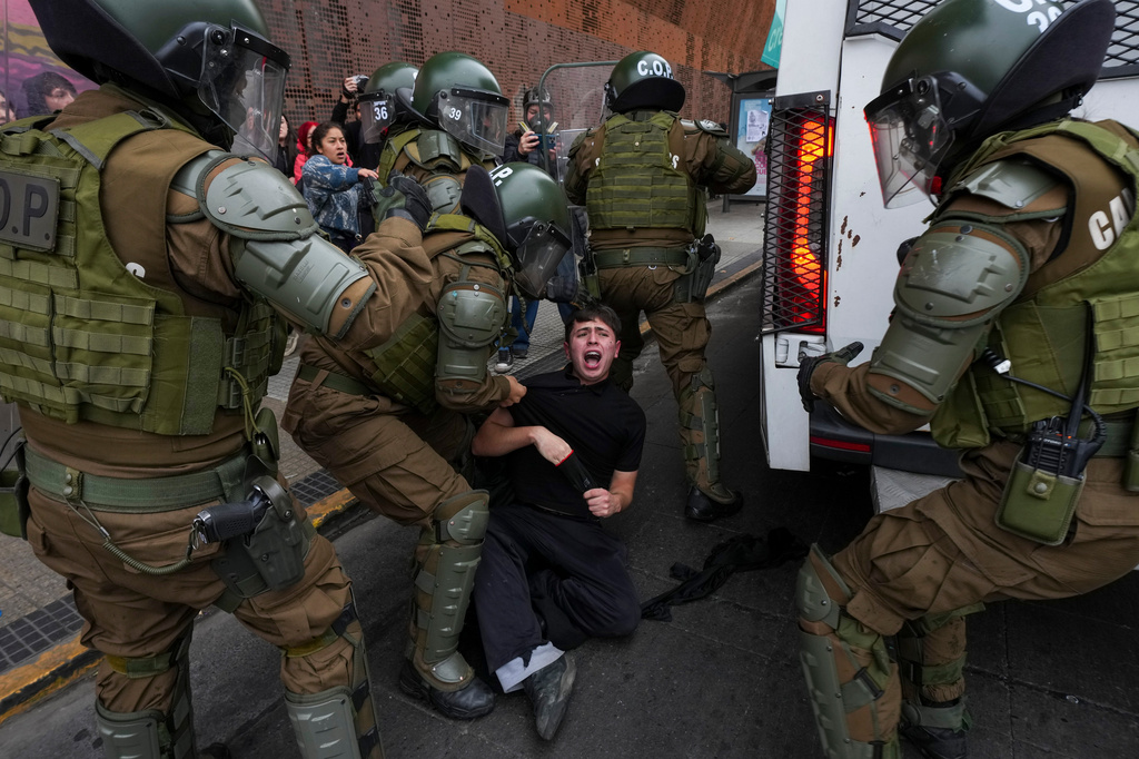 Police detain a student during a protest against the government's proposal to lower the education budget, in Santiago, Chile, Wednesday, June 3, 2026. (AP Photo/Esteban Felix)