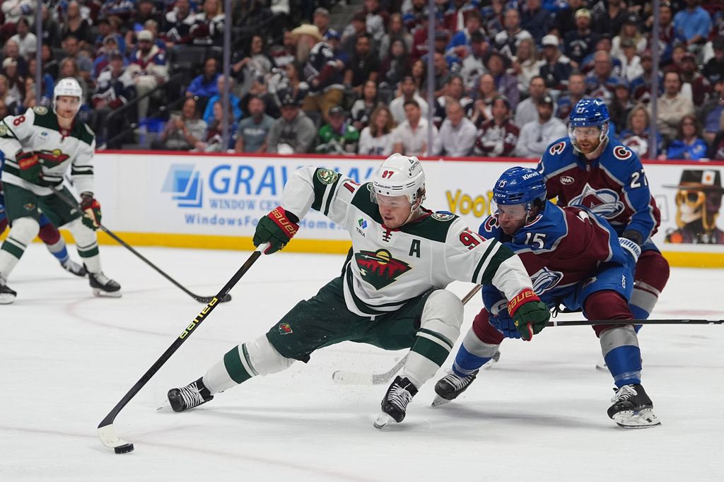 Minnesota Wild left wing Kirill Kaprizov, center, collects the puck as Colorado Avalanche defenseman Jack Ahcan covers in the second period of Game 5 of an NHL Stanley Cup hockey second-round playoff series, Wednesday, May 13, 2026, in Denver. (AP Photo/David Zalubowski)