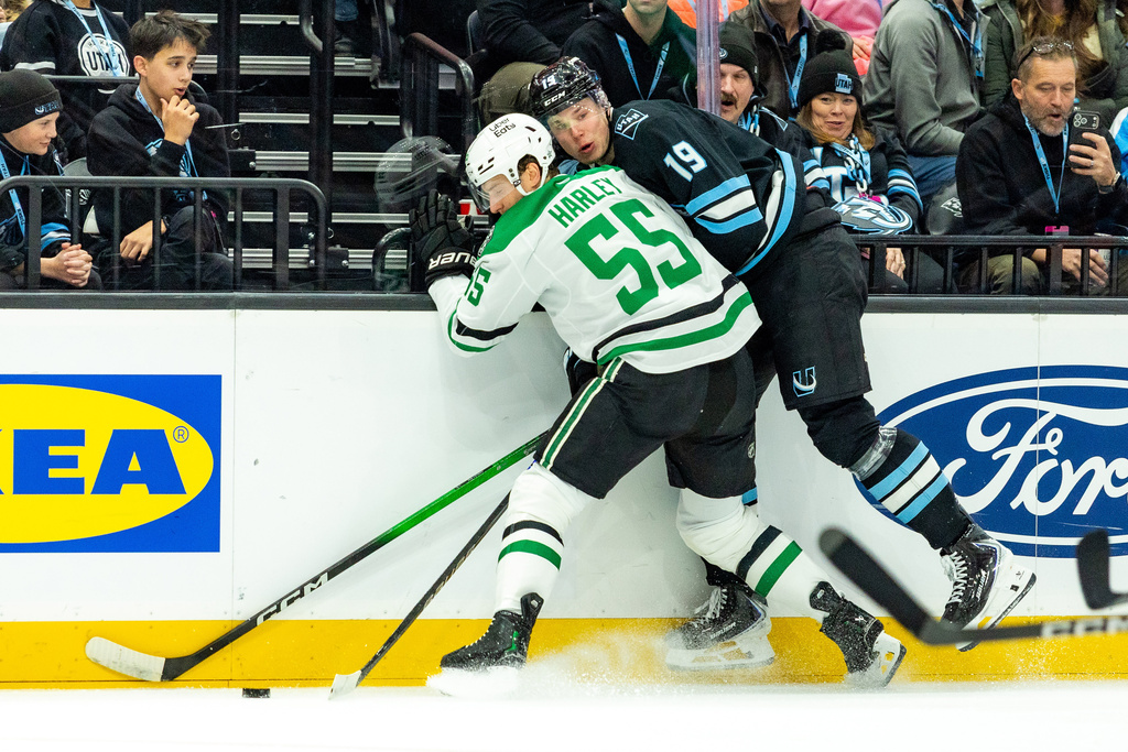 Utah Mammoth left wing Daniil But (19) fights for the puck against Dallas Stars defenseman Thomas Harley (55) during the first period of an NHL hockey game Saturday, Jan. 31, 2026, in Salt Lake City. (AP Photo/Melissa Majchrzak)