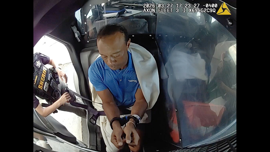 In this image from video provided by the Martin County, Fla., Sheriff's Office, golfer Tiger Woods is strapped into a police vehicle following a car crash in Jupiter Island, Fla., Friday, March 27, 2026. (Martin County Sheriff's Office via AP)