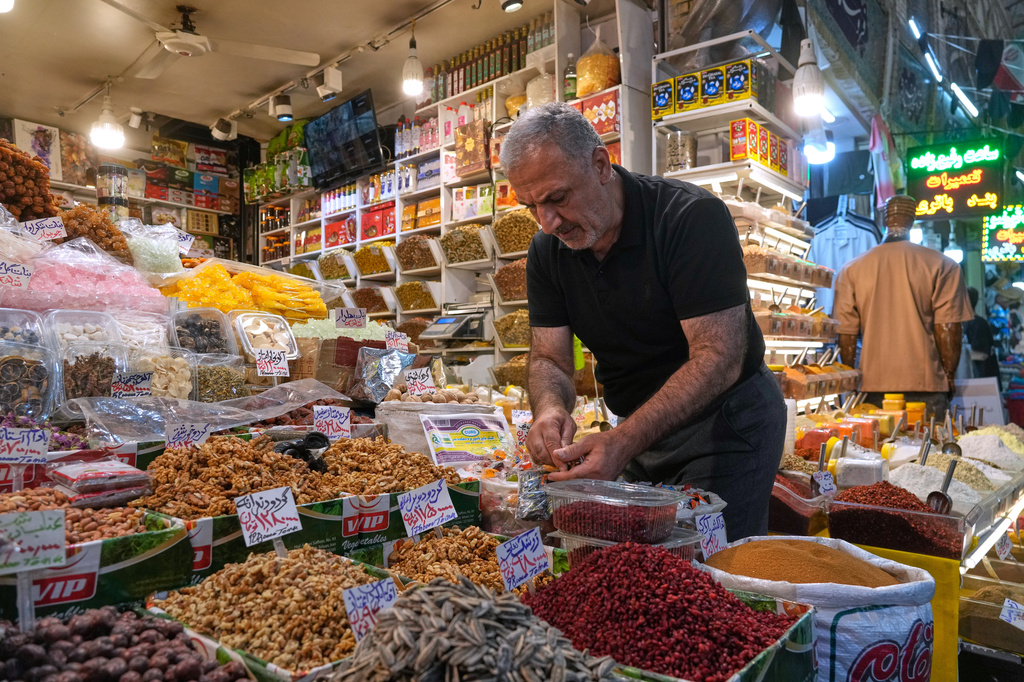 A shopkeeper arranges nuts at his shop at Tajrish traditional bazaar in northern Tehran, Iran, Sunday, Aug. 2, 2026. (AP Photo/Vahid Salemi)