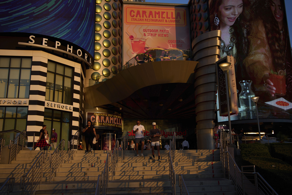 People walk along the Las Vegas Strip, Friday, Aug. 8, 2025, in Las Vegas. (AP Photo/John Locher)