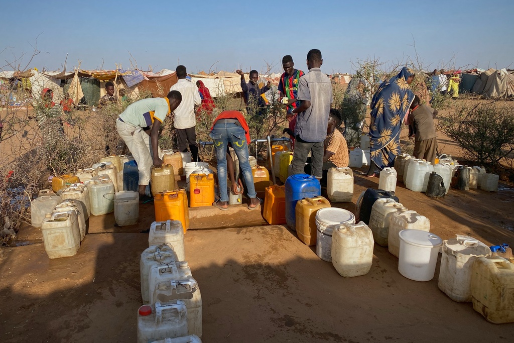 Sudanese men who fled el-Fasher city, after Sudan's paramilitary forces killed hundreds of people in the western Darfur region, collect water at a camp in Tawila, Sudan, Saturday, Nov. 1, 2025. (AP Photo/Mohammed Bakry)