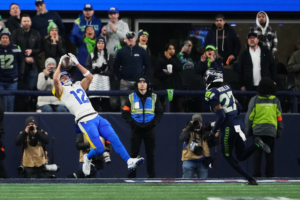 Los Angeles Rams wide receiver Puka Nacua (12) makes a touchdown catch past Seattle Seahawks cornerback Riq Woolen (27) during the second half of the NFC Championship NFL football game Sunday, Jan. 25, 2026, in Seattle. (AP Photo/Lindsey Wasson)