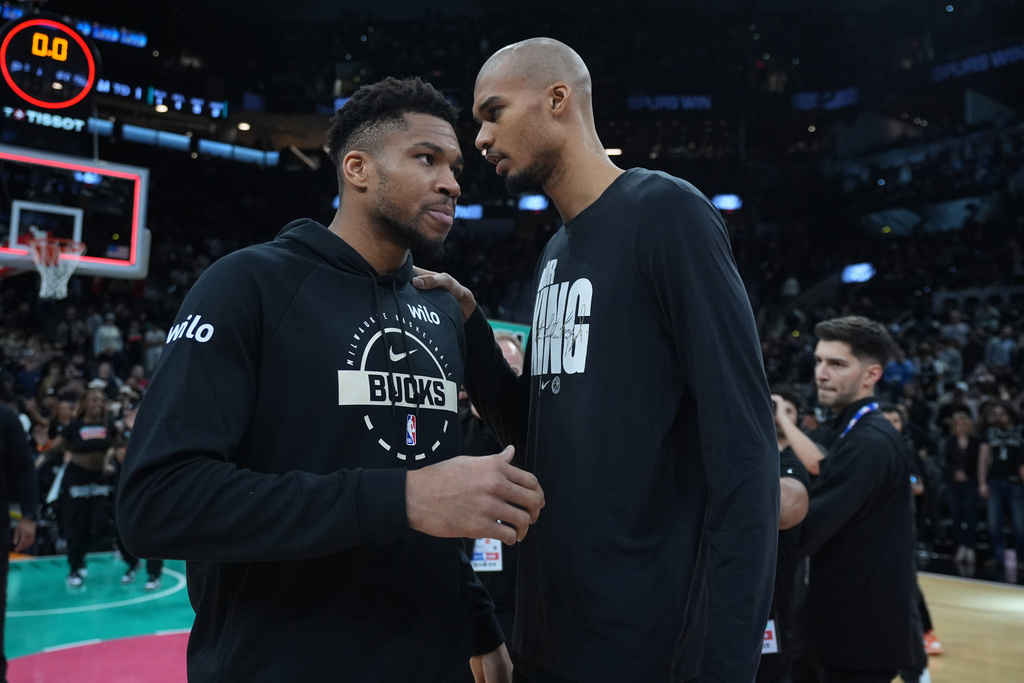 Milwaukee Bucks forward Giannis Antetokounmpo, left, and San Antonio Spurs forward Victor Wembanyama, right, visit following their NBA basketball game in San Antonio, Thursday, Jan. 15, 2026. (AP Photo/Eric Gay)