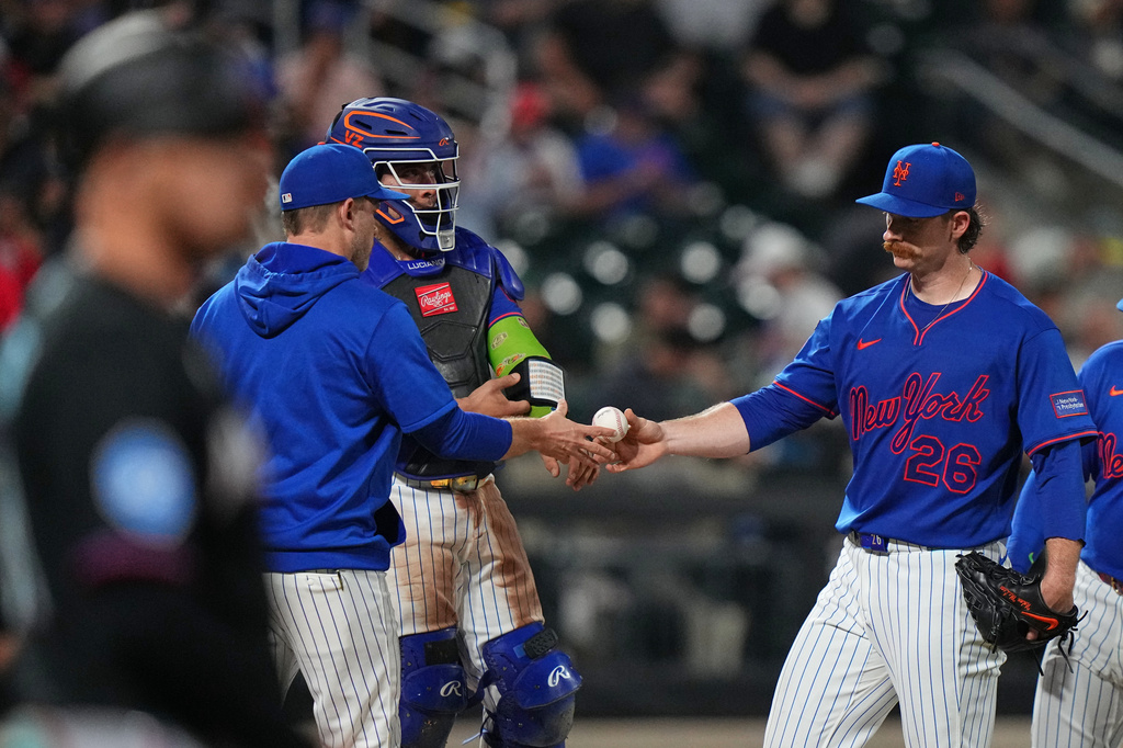 New York Mets pitcher Nolan McLean hands the ball to interim manager Andy Green as he leaves during the seventh inning of a baseball game against the Miami Marlins Thursday, July 30, 2026, in New York. (AP Photo/Frank Franklin II)