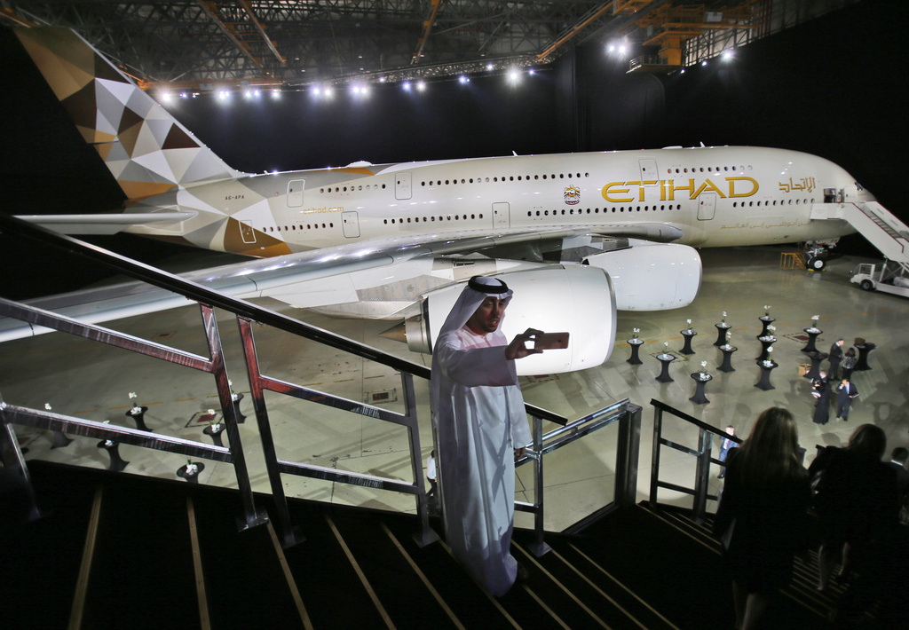 FILE - In this Dec. 18, 2014, file photo, an Emirati man takes a selfie in front of a new Etihad Airways A380 in Abu Dhabi, United Arab Emirates. (AP Photo/Kamran Jebreili, File)
