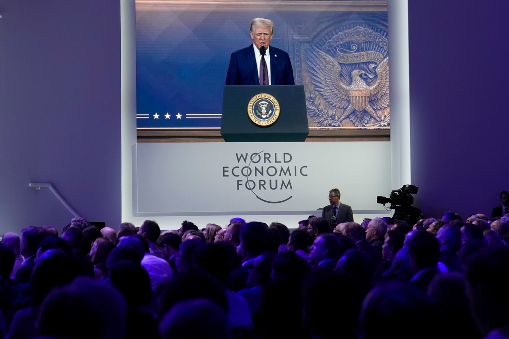 FILE - Attendees listen to a virtual speech delivered by U.S. president Donald Trump, at the Annual Meeting of World Economic Forum in Davos, Switzerland, Thursday, Jan. 23, 2025. (AP Photo/Markus Schreiber, file)