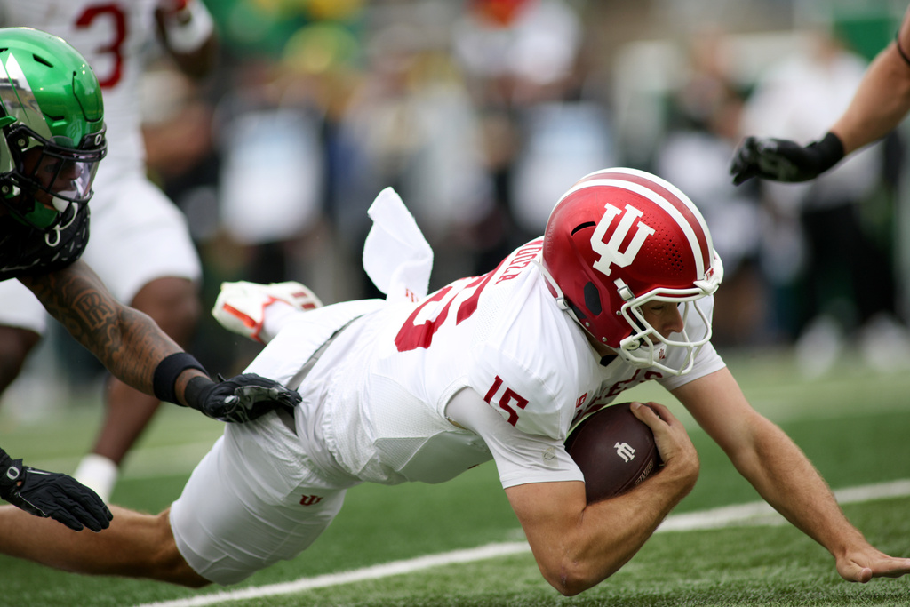 Indiana quarterback Fernando Mendoza (15) slides with the ball during the first half of an NCAA college football game against Oregon, Saturday, Oct. 11, 2025, in Eugene, Ore. (AP Photo/Lydia Ely)