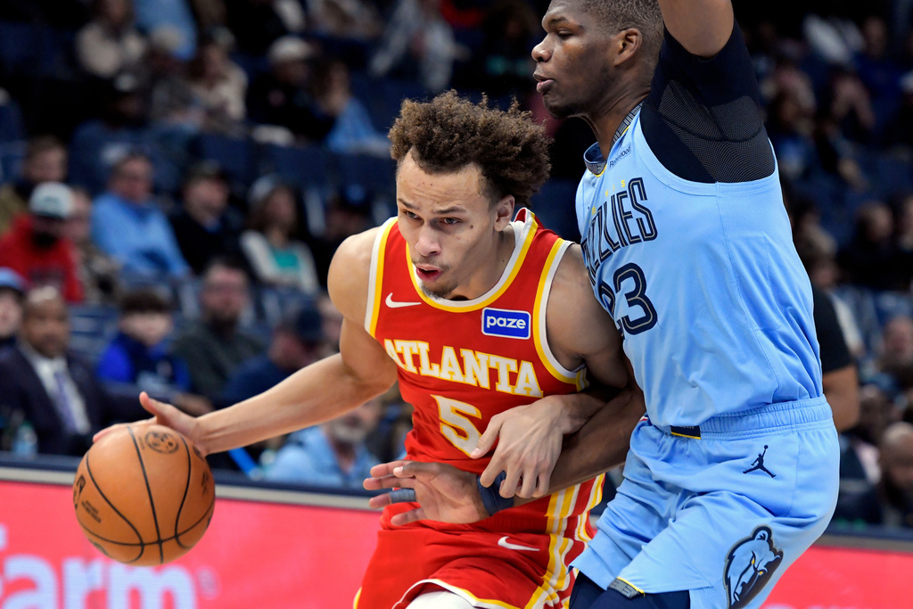 Atlanta Hawks guard Dyson Daniels (5) handles the ball against Memphis Grizzlies forward Cedric Coward (23) in the first half of an NBA basketball game Wednesday, Jan. 21, 2026, in Memphis, Tenn. (AP Photo/Brandon Dill)