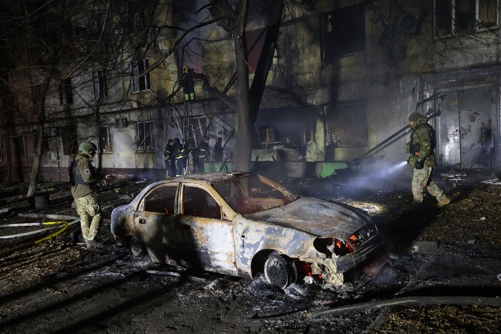 Rescue workers try to put out a fire of a residential building burning after a Russian attack on Zaporizhzhia, Ukraine, Wednesday, Nov. 26, 2025. (AP Photo/Kateryna Klochko)