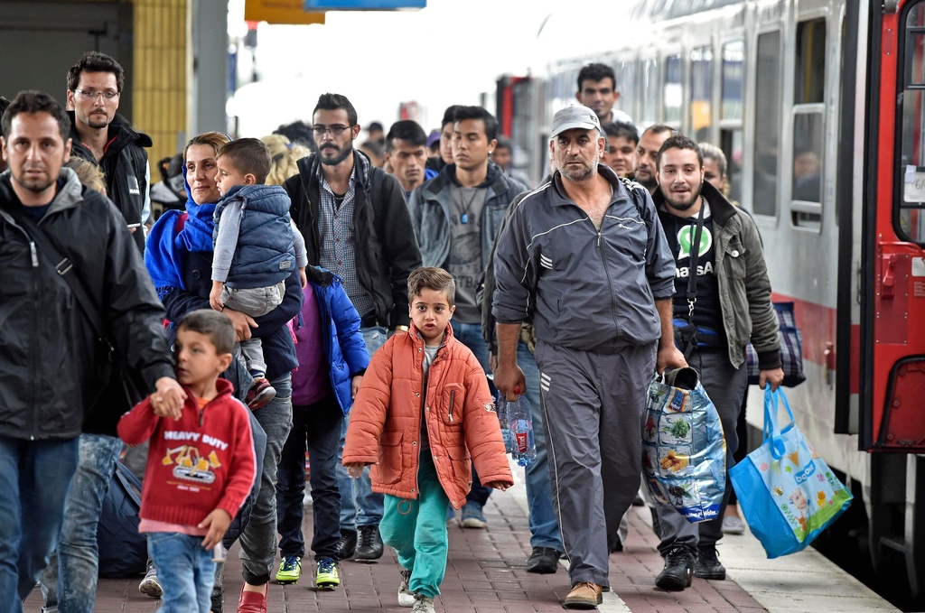 FILE - Refugees from Syria arrive at the train station in Dortmund, Germany, Sept. 6, 2015. (AP Photo/Martin Meissner, File)