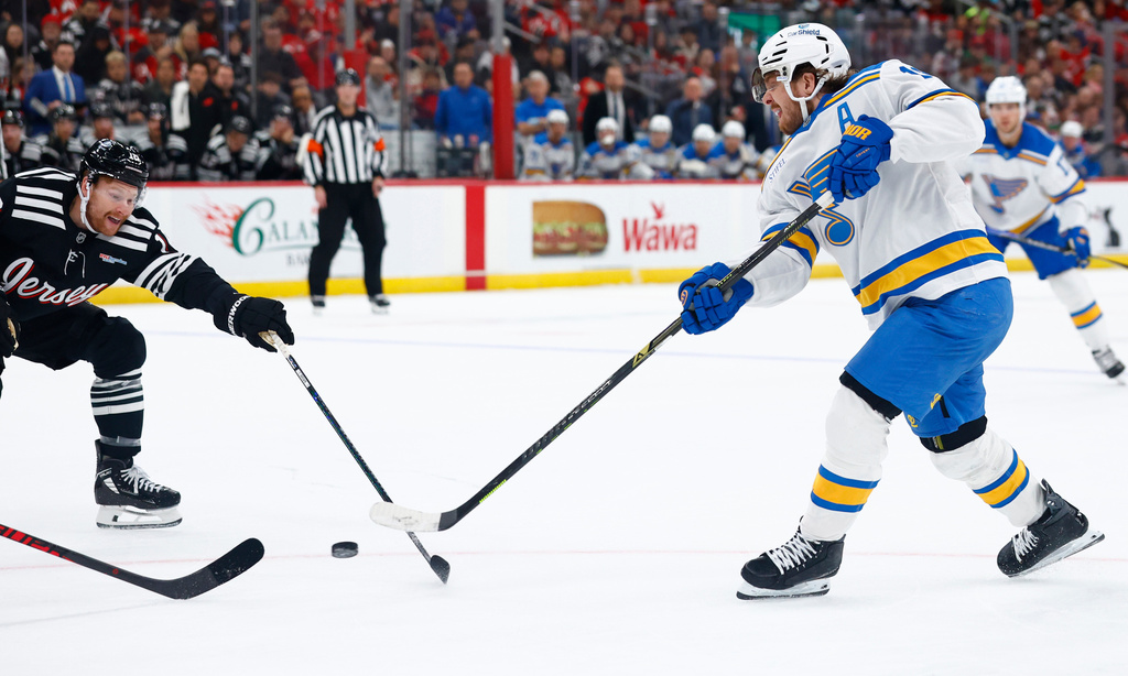 St. Louis Blues center Robert Thomas (18) scores a goal in front of New Jersey Devils left wing Ondrej Palat (18) during the first period of an NHL hockey game, Wednesday, Nov. 26, 2025, in Newark, N.J. (AP Photo/Noah K. Murray)