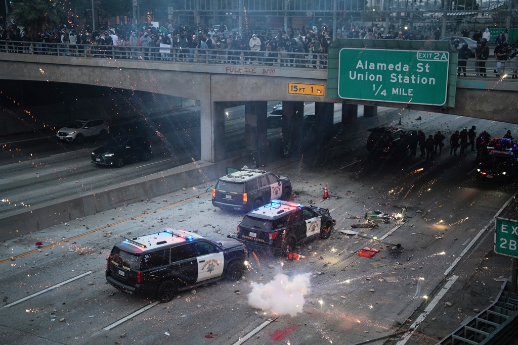 EDS NOTE: OBSCENITY A flash bomb explodes on the 101 Freeway near the metropolitan detention center of downtown Los Angeles, June 8, 2025, following an immigration raid protest the night before. (AP Photo/Eric Thayer, File)