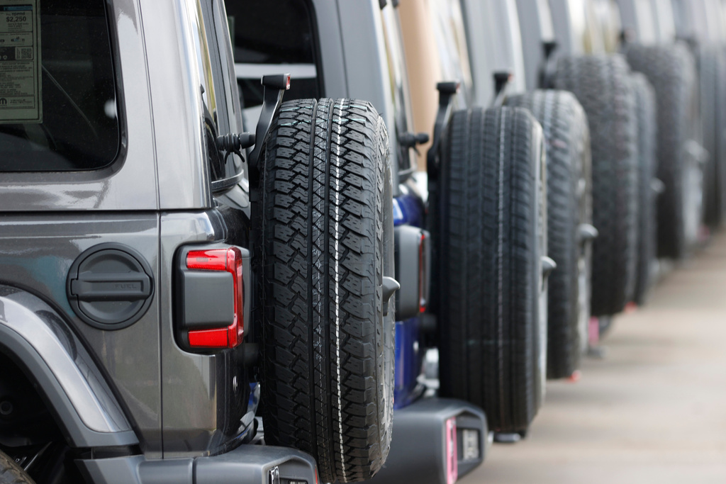 FILE - Spare tires are seen on a long row of unsold 2020 Wranglers sit at a Jeep dealership in Englewood, Colo., on April 26, 2020. (AP Photo/David Zalubowski, File)