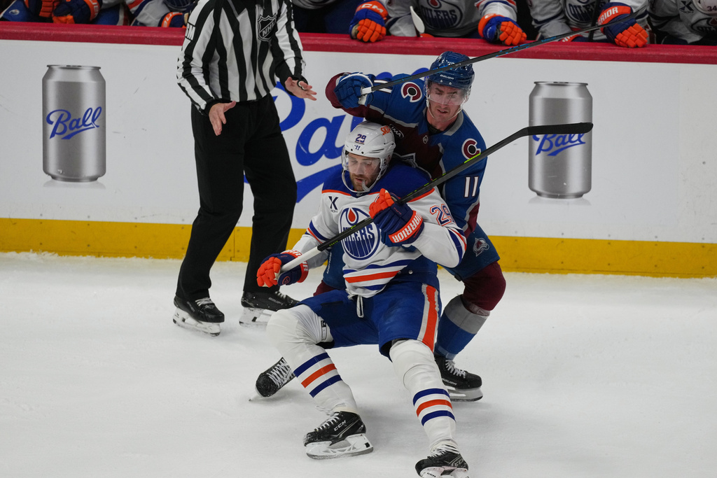 Edmonton Oilers center Leon Draisaitl, front, gets tied up by Colorado Avalanche center Brock Nelson in the first period of an NHL hockey game, Tuesday, March 10, 2026, in Denver. (AP Photo/David Zalubowski)