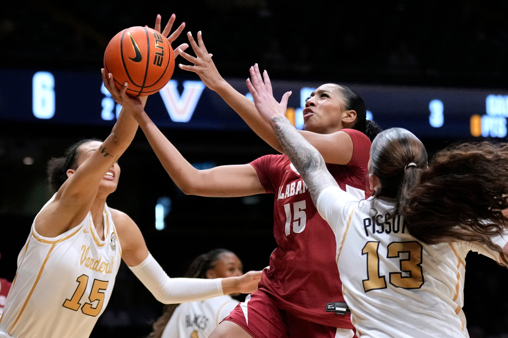 Alabama's Ta'mia Scott, center, drives between Vanderbilt's Ndjakalenga Mwenentanda, left, and Justine Pissott (13) in the first half of an NCAA college basketball game Thursday, Feb. 26, 2026, in Nashville, Tenn. (AP Photo/Mark Humphrey)