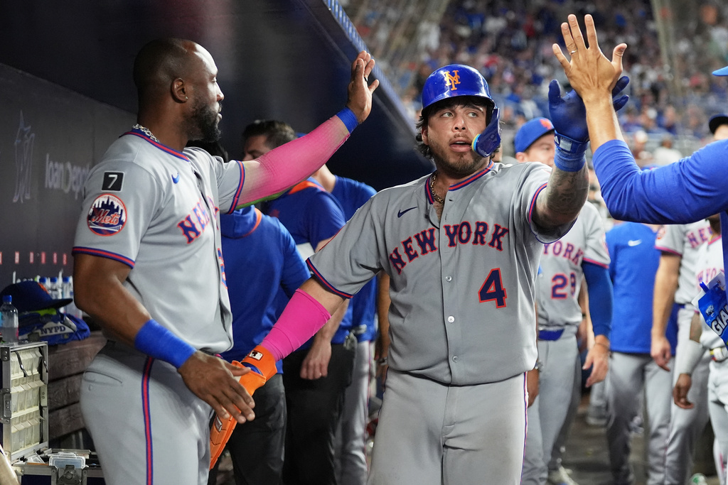 New York Mets' Francisco Alvarez (4) is congratulated in the dugout after scoring on a RBI single hit by Francisco Lindor during the ninth inning of a baseball game, Saturday, Sept. 27, 2025, in Miami. (AP Photo/Lynne Sladky)
