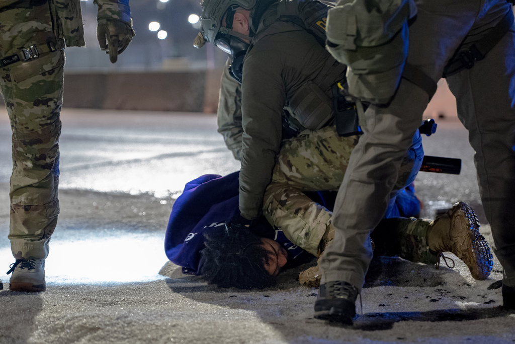 Federal immigration officers detain a demonstrator outside Bishop Whipple Federal Building after tear gas was deployed Monday, Jan. 12, 2026, in Minneapolis. (AP Photo/Jen Golbeck)
