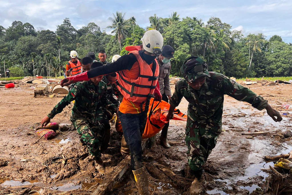 Rescuers carry the body of a flood victim, in Agam, West Sumatra, Indonesia, Sunday, Nov. 30, 2025. (AP Photo/Ade Yuandha)