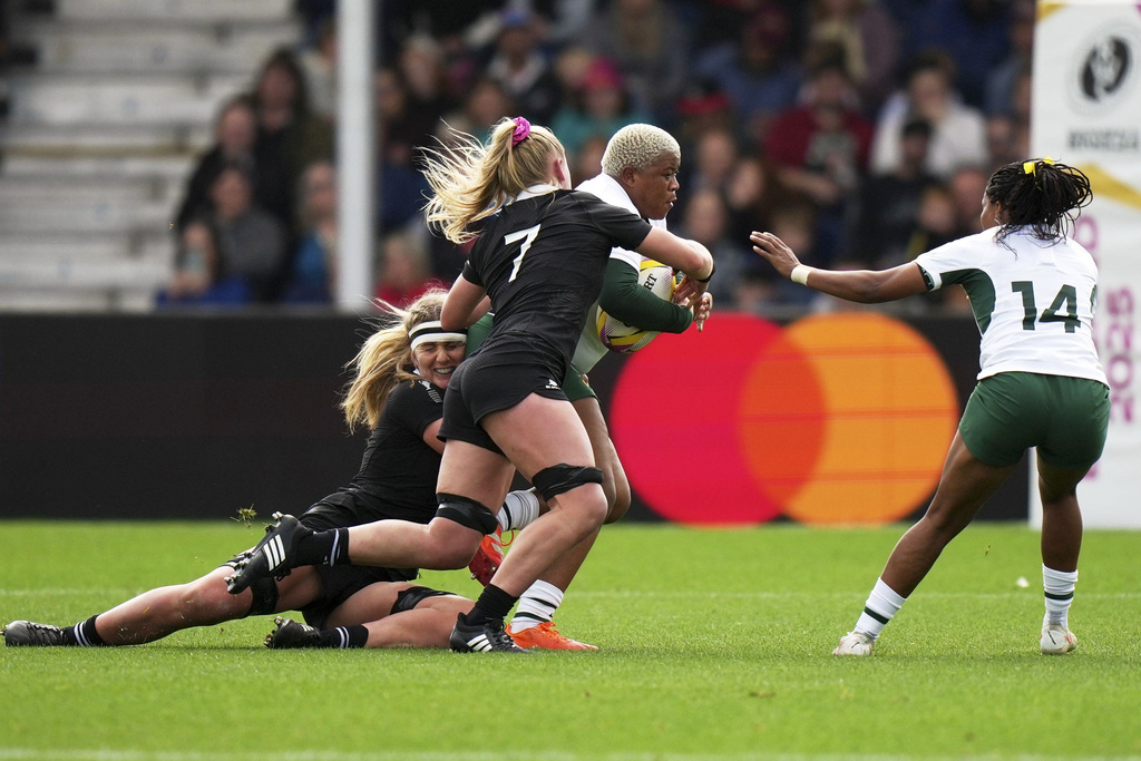 South Africa's Aphiwe Ngwevu, centre, tackled by New Zealand's Alana Bremner, bottom, and teammate Jorja Miller during the Women's Rugby World Cup 2025 quarterfinal match between New Zealand and South Africa, in Exeter, England, Saturday, Sept. 13, 2025. (AP Photo/Alastair Grant)
