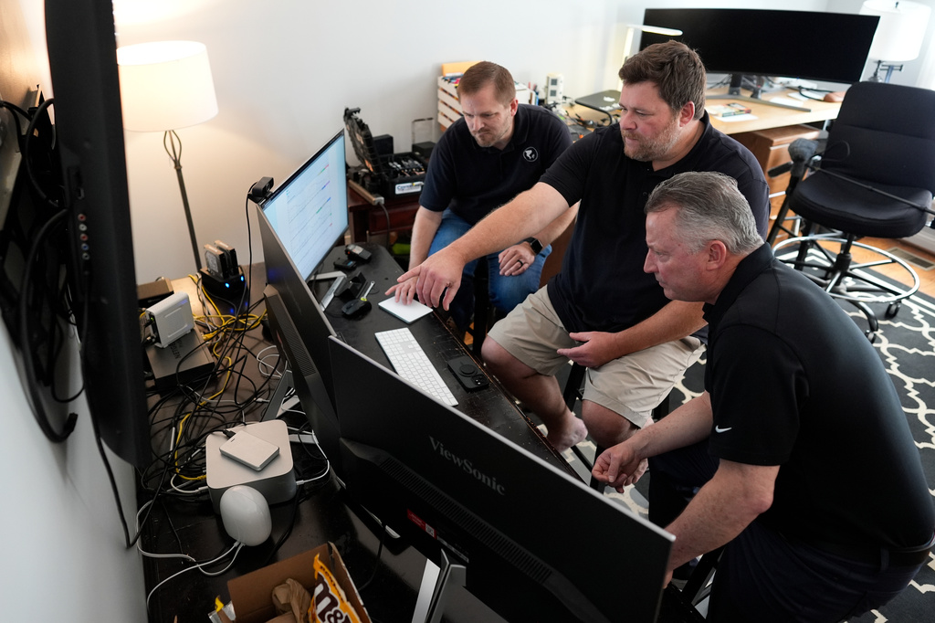Andrew Leeper, left, Will Minkoff and Tom Johnstone, right, of Nashville Severe Weather, look over weather data Monday, April 20, 2026, in Nashville, Tenn. (AP Photo/George Walker IV)