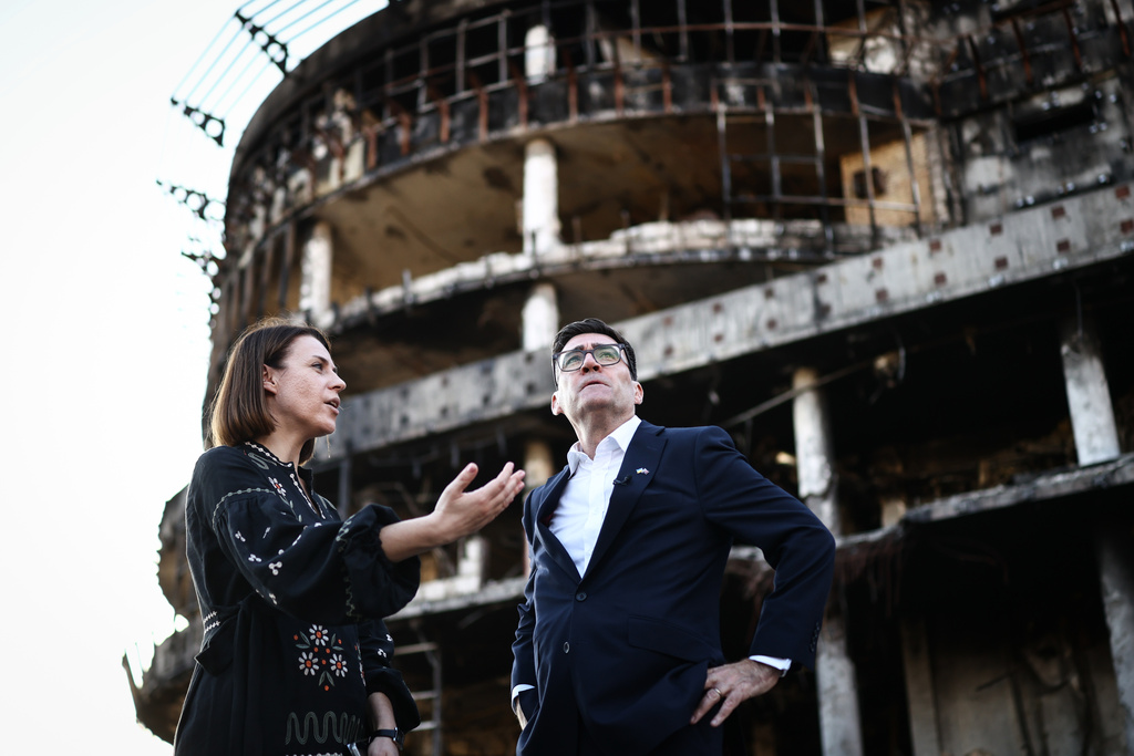 Britain's Prime Minister Andy Burnham reacts as he is shown the rubbles and wreckages left on the buildings and site of a strike by the Lukanivska market in Kyiv, Monday, Aug. 24, 2026. (Henry Nicholls/Pool Photo via AP)